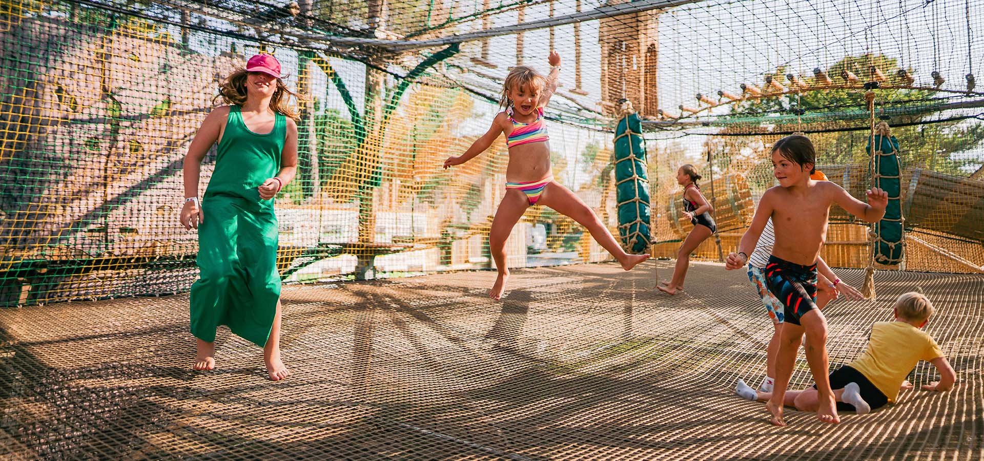 Camping san damiano aire de jeux trampolino filles garcon qui sautent